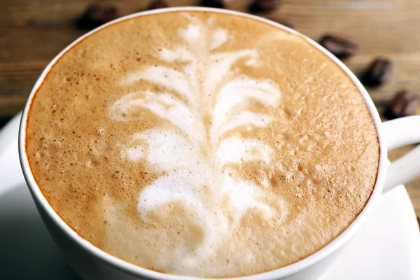 Cup of latte art coffee with grains, closeup — Stock Photo, Image