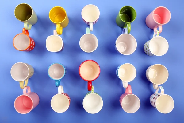 Group of colorful cups on color table, top view — Stock Photo, Image