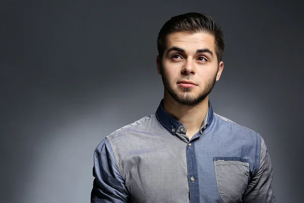 Retrato de um jovem de camisa azul sobre fundo cinza — Fotografia de Stock