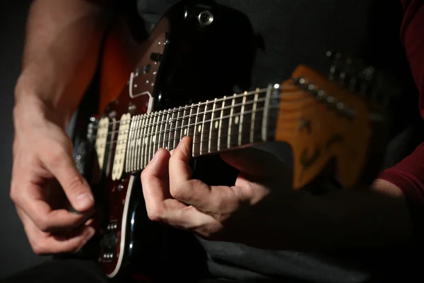 Ung man spelar på elgitarr på nära håll — Stockfoto