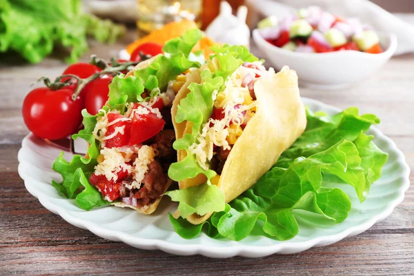 Taco saboroso com legumes no prato na mesa de perto — Fotografia de Stock