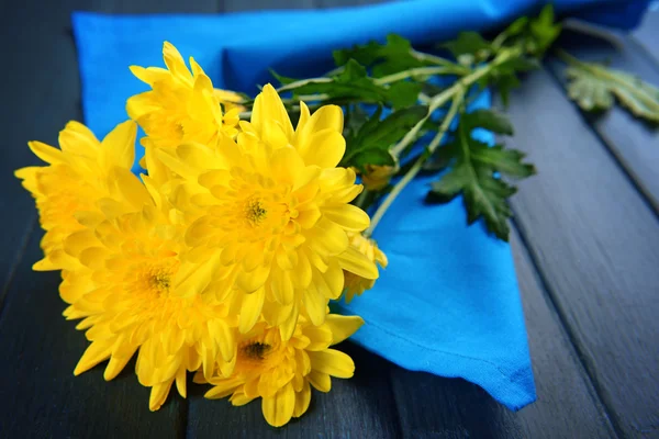 Krásnou kytici žlutých chryzantém s ubrouskem na dřevěný stůl — Stock fotografie