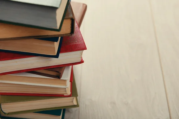 Стопка книг на деревянном фоне — стоковое фото