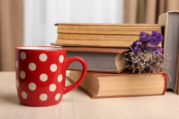 Boeken, cup en plant op houten tafel, close-up — Stockfoto