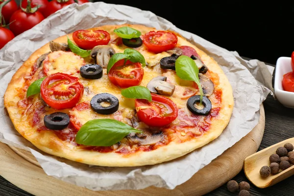 Pizza savoureuse avec légumes et basilic sur la table close up — Photo