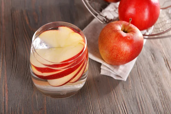Glass of apple cider with fruits on wooden background — Stock Photo, Image