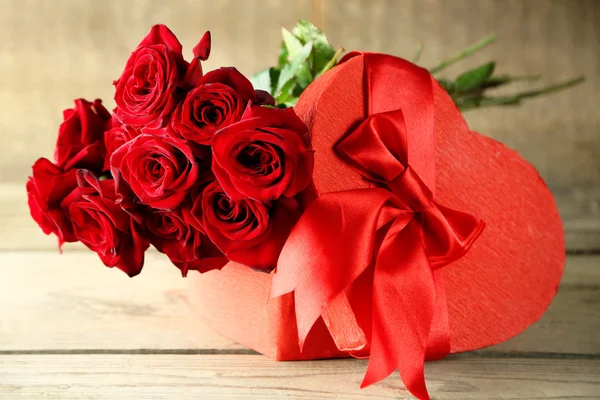 Caja de regalo de San Valentín en forma de corazón con rosas rojas en la vieja mesa de madera — Foto de Stock