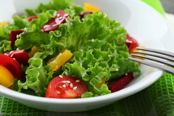 Ciotola di insalata verde fresca sul tavolo con tovagliolo, primo piano — Foto Stock