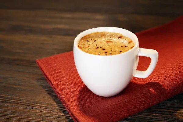 Cup of coffee on napkin on table close up — Stock Photo, Image