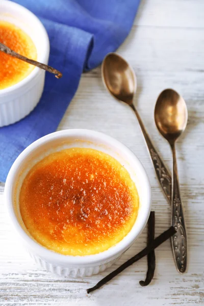 Creme brulee sobremesa no guardanapo, na cor de fundo de madeira — Fotografia de Stock