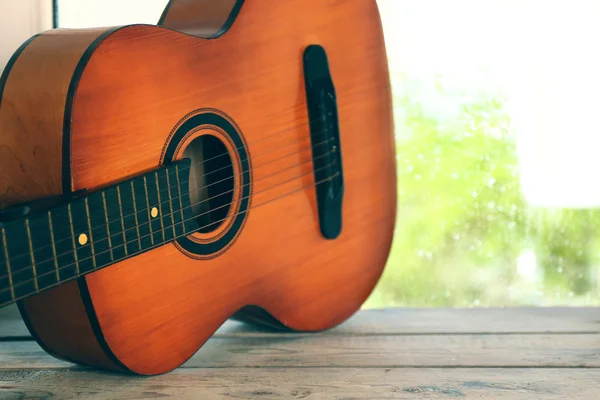 Guitare acoustique à côté de la fenêtre avec gouttes de pluie — Photo