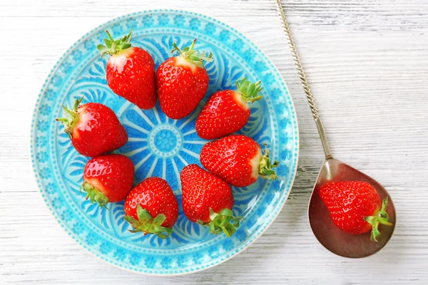 Φράουλες στο πιάτο χρώμα, σε ξύλινο φόντο χρώμα — Φωτογραφία Αρχείου