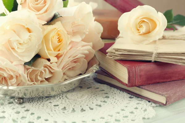 新鲜的玫瑰与旧书和色木桌背景上的字母。老式的概念 — 图库照片