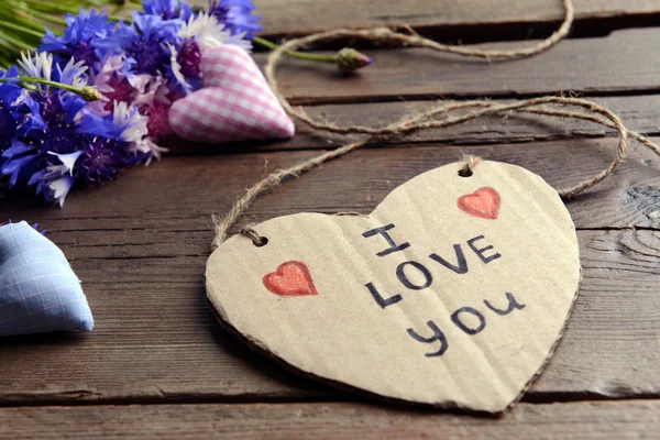Mensagem escrita com flores secas e corações decorativos na mesa de madeira close up — Fotografia de Stock