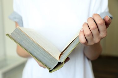 Kadın odada kitap okuyor.