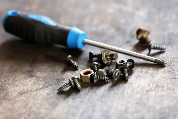 Screwdriver with heap of nuts and bolts — Stock Photo, Image