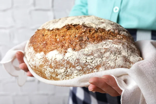 Mulher segurando saboroso pão fresco — Fotografia de Stock