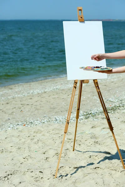 Female hand holding palette with paints — Stock Photo, Image