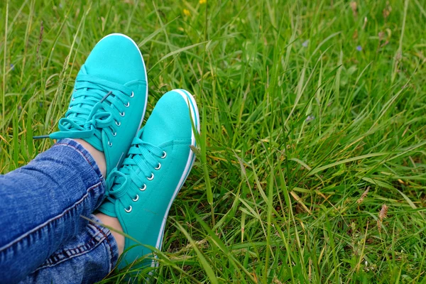 Pies femeninos en zapatos de goma sobre fondo de hierba verde —  Fotos de Stock