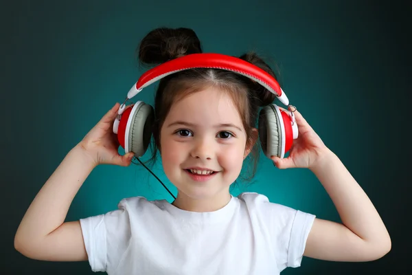 漂亮的小女孩，在彩色背景上听音乐漂亮的小女孩，在彩色背景上听音乐 — 图库照片