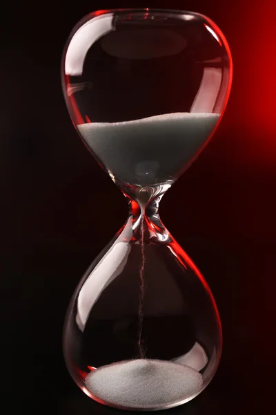 Hourglass on dark red background — Stock Photo, Image