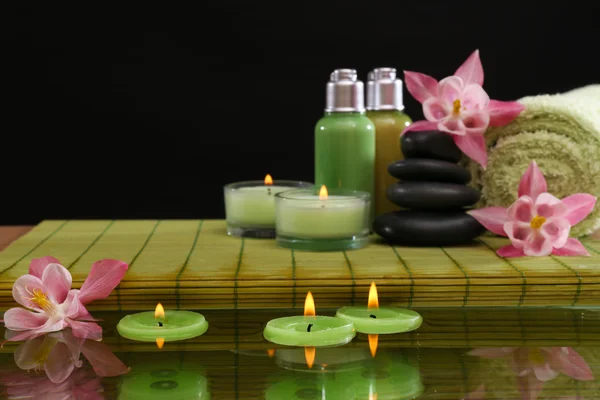 Bodegón Spa con flores y velas sobre fondo negro — Foto de Stock