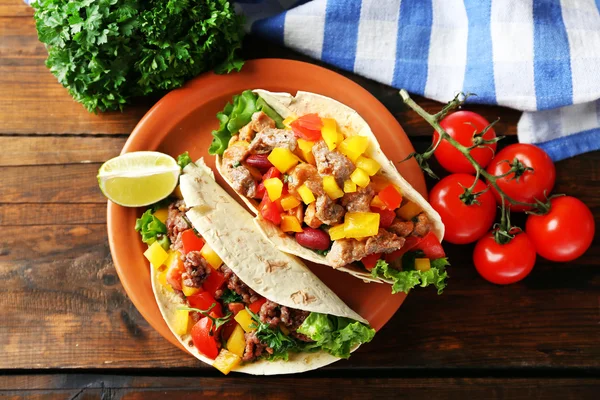Burritos domowe wołowiny z warzywami na talerzu, na tle drewniane — Zdjęcie stockowe