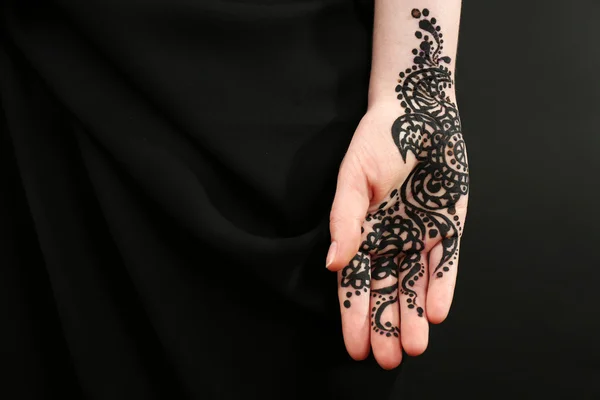 Image rapprochée de henné sur main féminine sur fond sombre — Photo