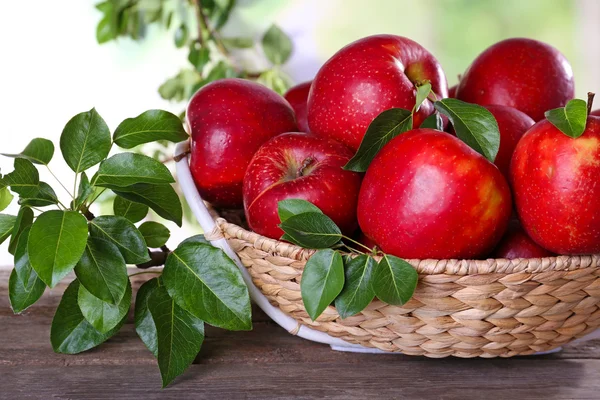 Красное яблоко в плетеной корзине — стоковое фото