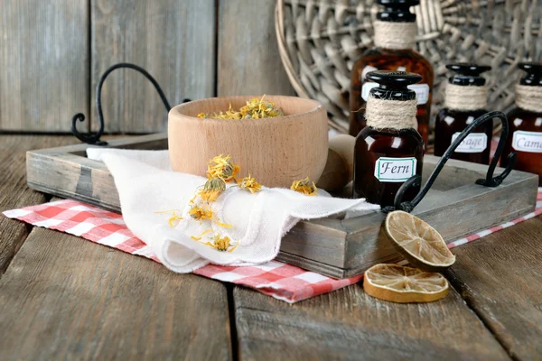 Dried herbs and bottles with tinctures on table close up — Stock Photo, Image