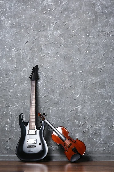 Guitare électrique et violon sur mur gris — Photo