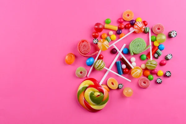 Красочные конфеты на розовом фоне — стоковое фото