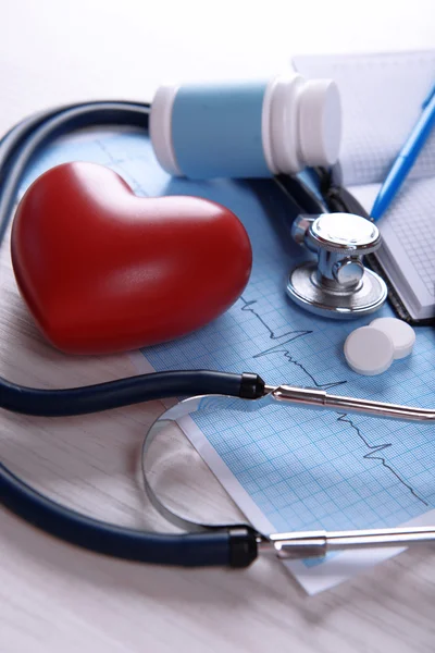 Кардиограмма со стетоскопом и красным сердцем — стоковое фото