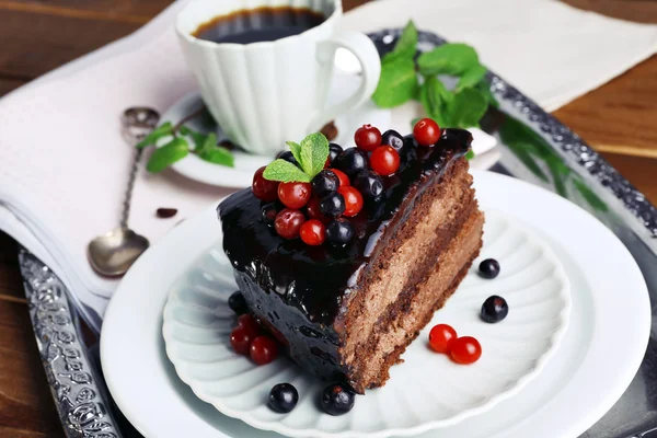 Delicioso pastel de chocolate con bayas y taza de café — Foto de Stock