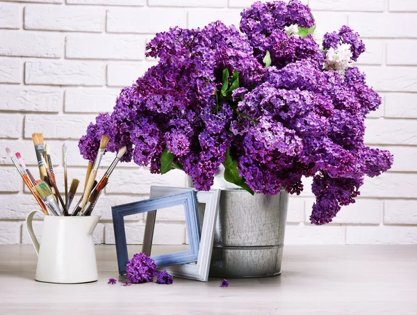 Beautiful lilac flowers in pail on floor — Stock Photo, Image