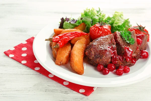 Tasty roasted meat with cranberry sauce and roasted vegetables