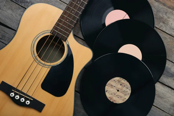 Chitarra e dischi in vinile su tavolo di legno — Foto Stock
