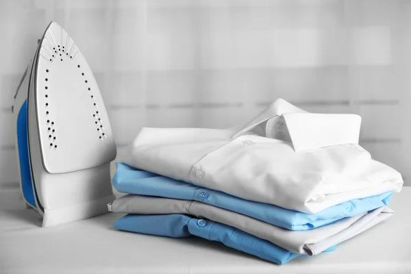 Pile of clothes and electric iron — Stock Image Pile of clothes and electric iron Stock Image