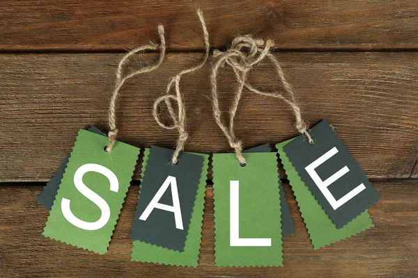 Sale tags on wooden background — Stock Photo, Image