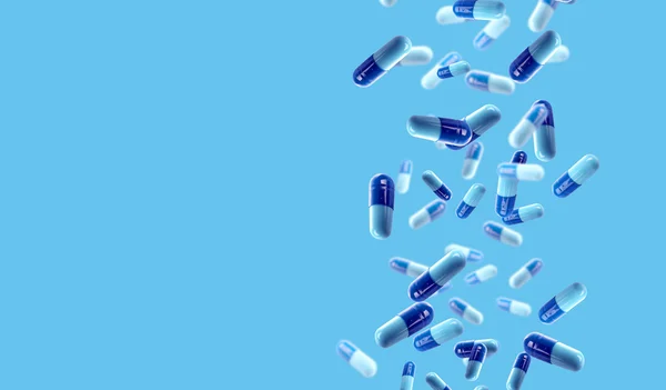 La caída de las píldoras médicas sobre fondo azul —  Fotos de Stock