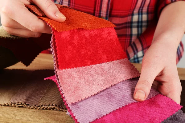 Femme choisit des morceaux de tissu coloré sur la table gros plan — Photo