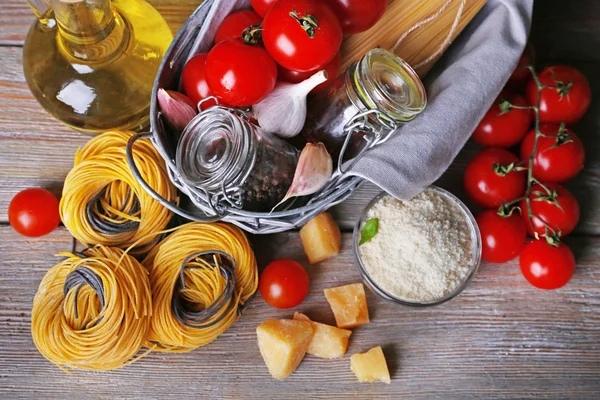 Pasta con pomodorini e altri ingredienti su fondo tavola in legno — Foto Stock