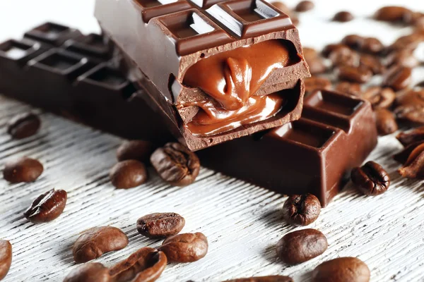 Ahşap masa, closeup üzerinde kahve çekirdekleri ile doldurulmuş çikolata — Stok fotoğraf