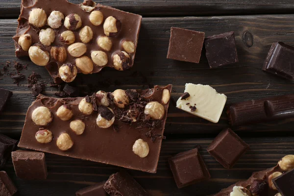 Schokoladenset mit Haselnuss auf Holztisch, Ansicht von oben — Stockfoto