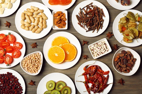 Different products on saucers on wooden table, top view — Stock Photo, Image