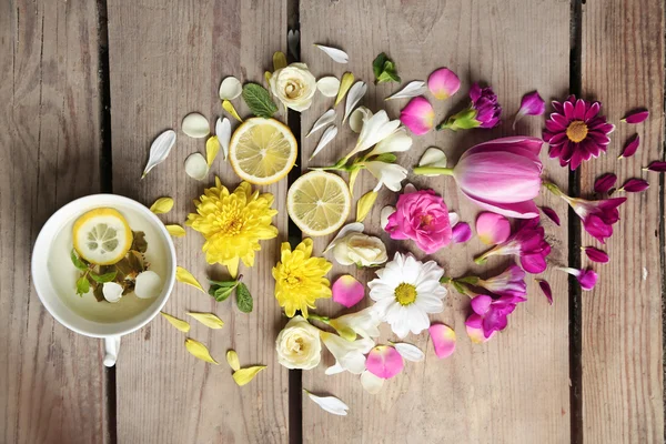 Чашка травяного чая с красивыми цветами, на деревянном фоне — стоковое фото