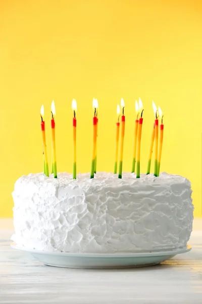 Torta di compleanno con candele su sfondo a colori — Foto Stock