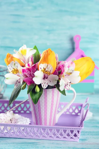 Bellissimi fiori in tazza, su sfondo di legno a colori — Foto Stock