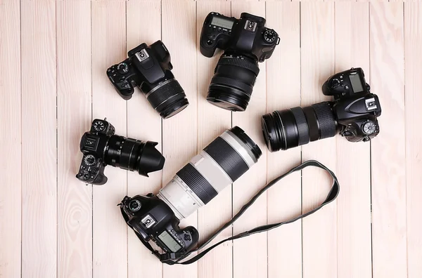 Modern cameras on wooden table, top view — Stock Photo, Image