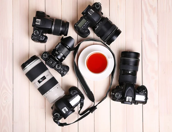 Telecamere moderne con tazza di tè sul tavolo in legno, vista dall'alto — Foto Stock